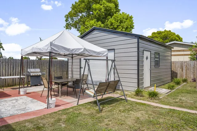 a backyard of a house with table and chairs