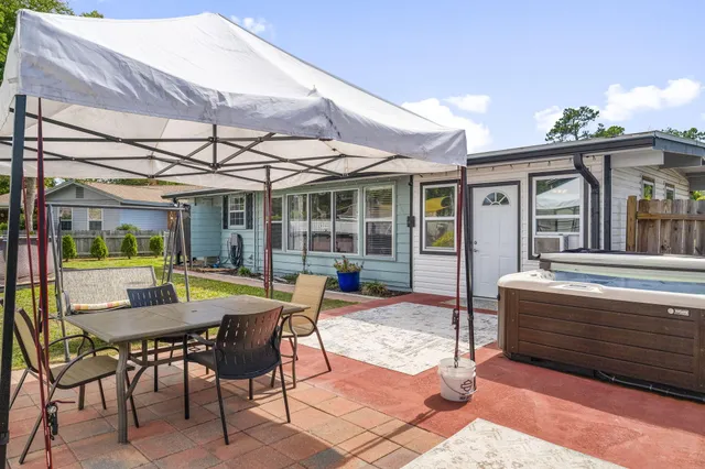 a view of a patio with a table and chairs under an umbrella