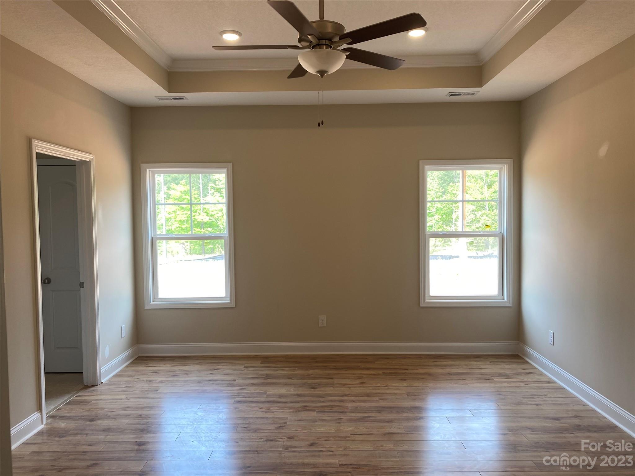 8018 Smooth Stone Court, Unit 71 Clover, SC 29710 - Photo 6 of 21 an empty room with wooden floor windows and fan
