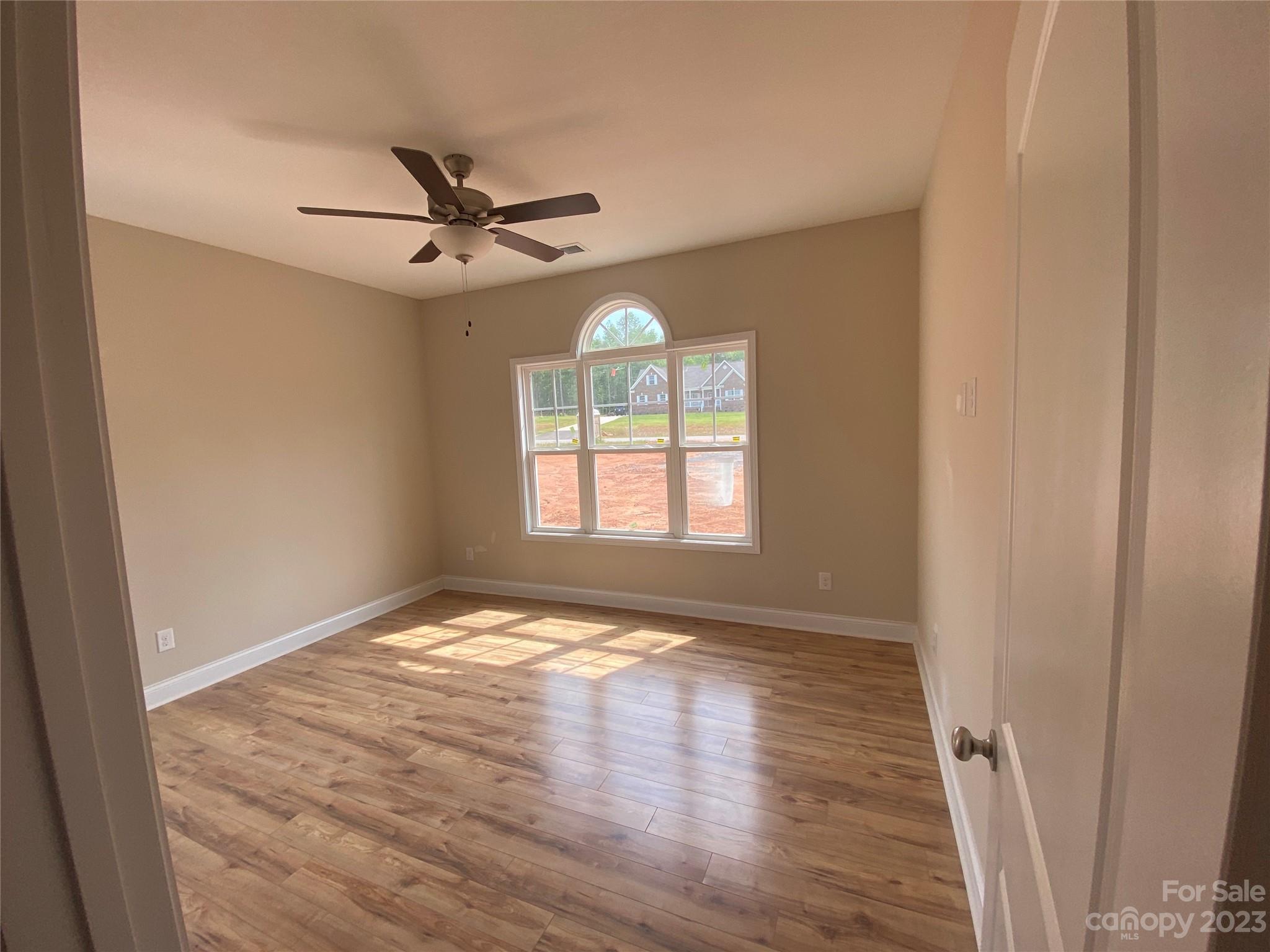 8018 Smooth Stone Court, Unit 71 Clover, SC 29710 - Photo 7 of 21 a view of an empty room with window and wooden floor