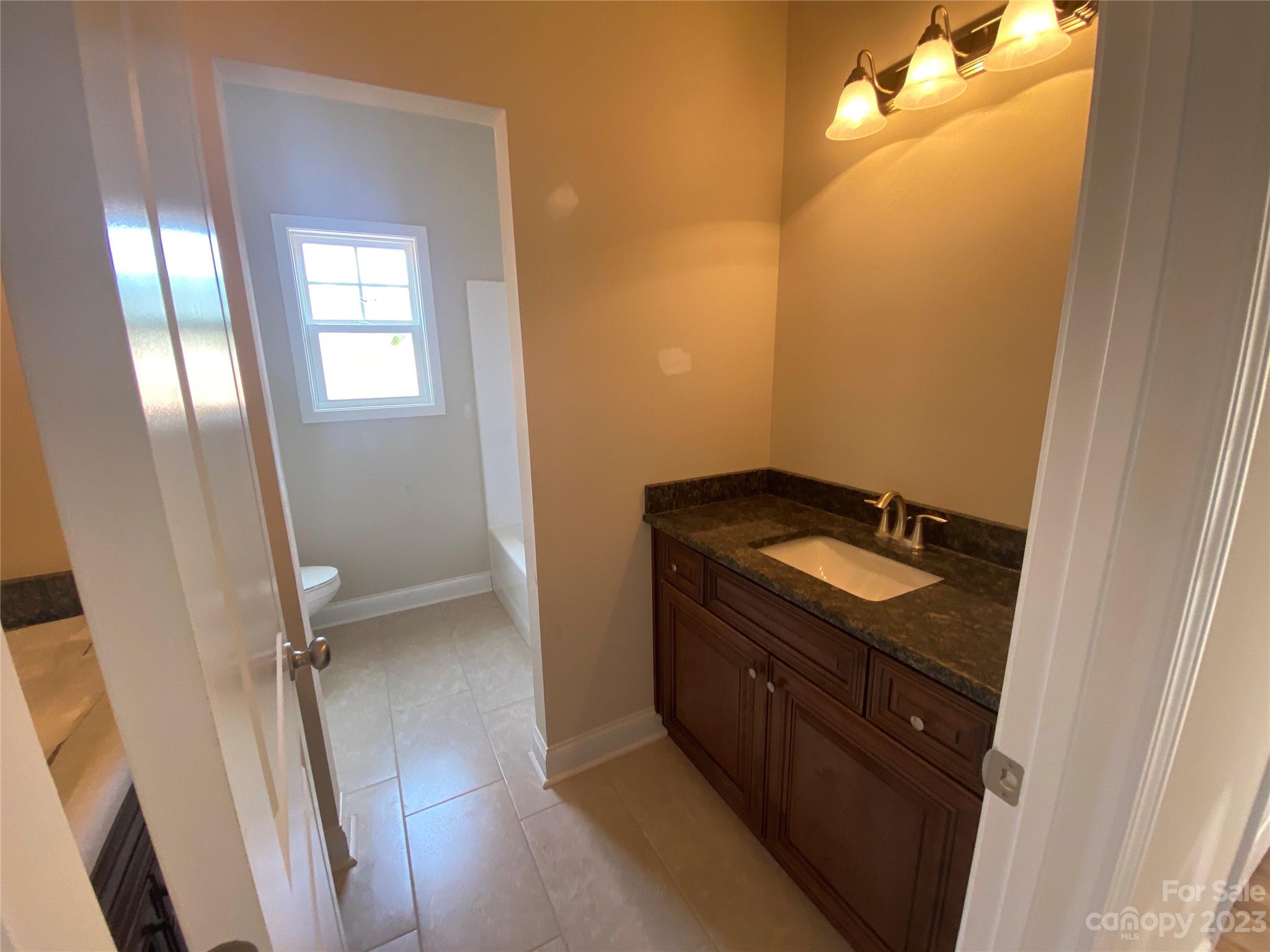 8018 Smooth Stone Court, Unit 71 Clover, SC 29710 - Photo 8 of 21 a bathroom with a granite countertop sink and a mirror