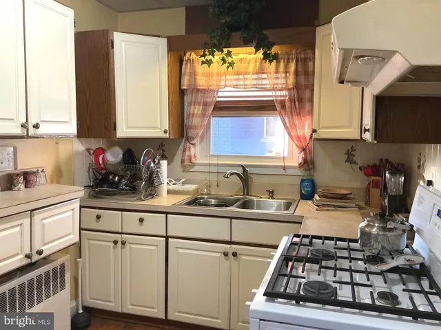 a kitchen with stainless steel appliances a sink a stove and white cabinets