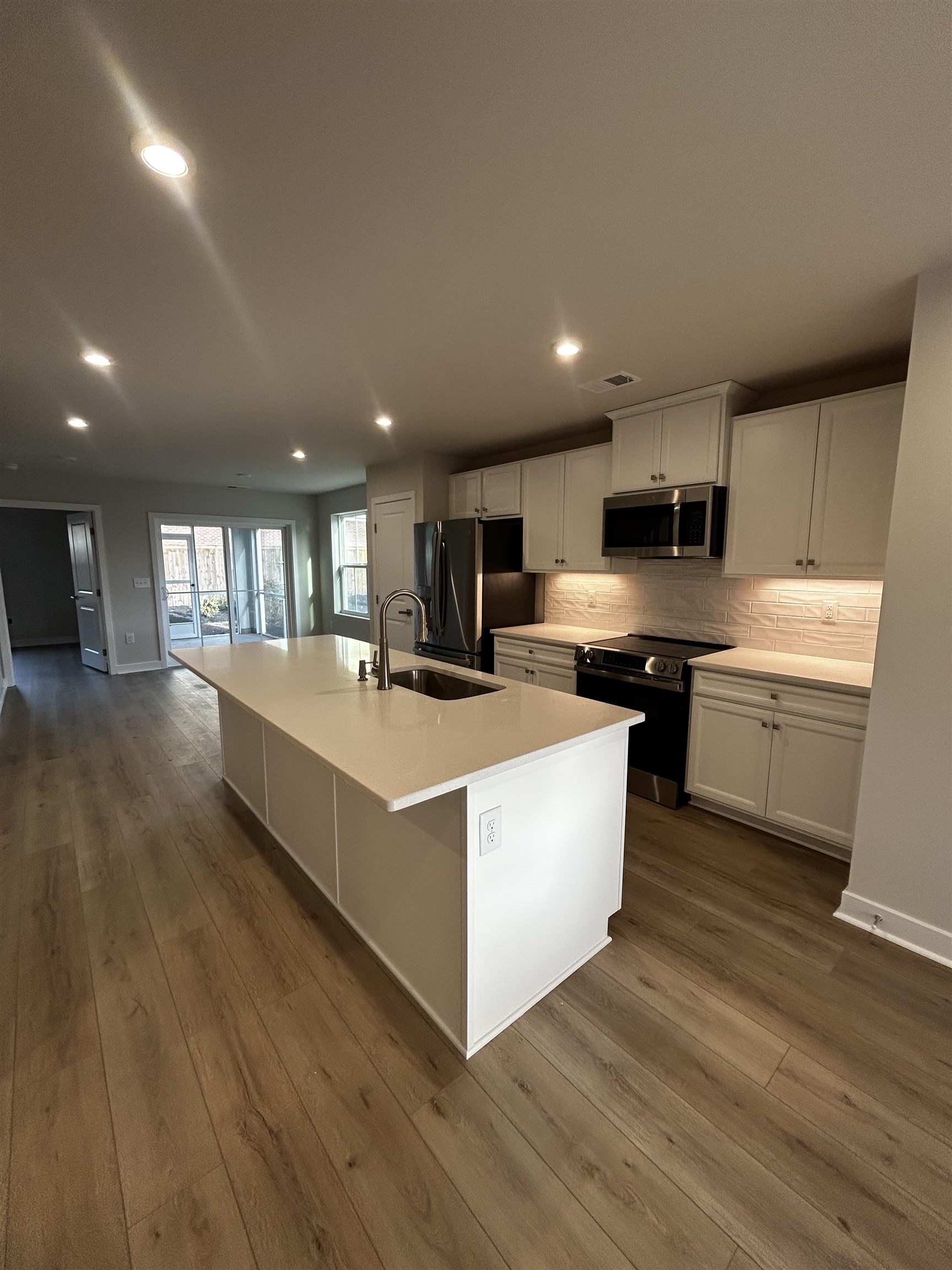 1301 Pleasant View Drive, Unit A North Myrtle Beach, SC 29582 - Photo 3 of 13 Kitchen featuring a center island with sink, electric range oven, white cabinets, fridge with ice dispenser, and stainless steel microwave
