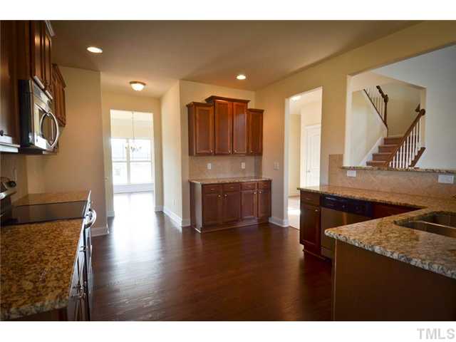 117 Weathers Street Rolesville, NC 27571 - Photo 3 of 16 Kitchen has hardwood floors, stainless steel appliances. View of turned staircase adjacent to family room.