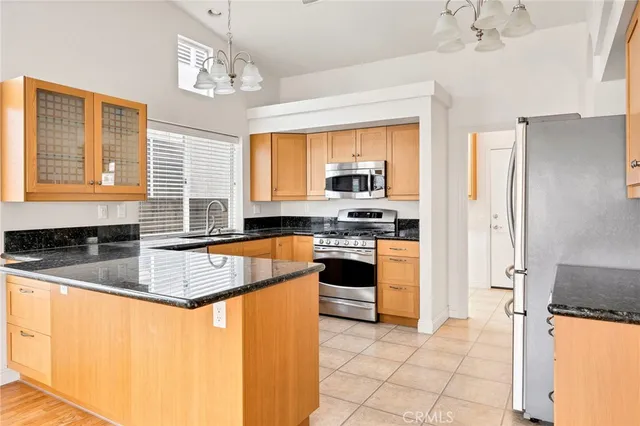 a kitchen with granite countertop cabinets stainless steel appliances a sink and a window