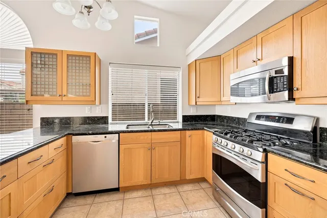 a large kitchen with granite countertop a sink and a stove