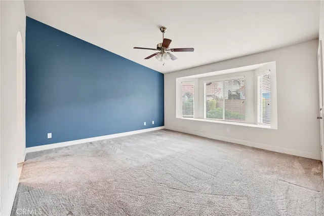 an empty room with a ceiling fan and window
