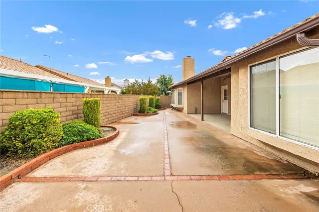 a view of a white house with a big yard and potted plants