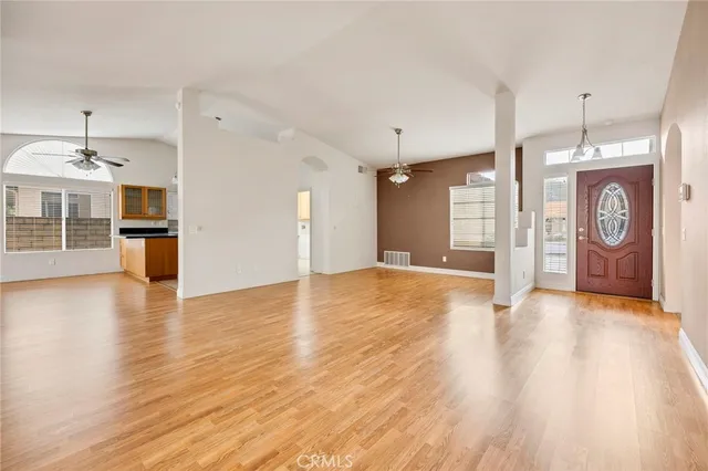 a view of a room with wooden floor and kitchen view