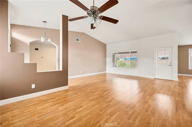 a view of empty room with wooden floor and windows