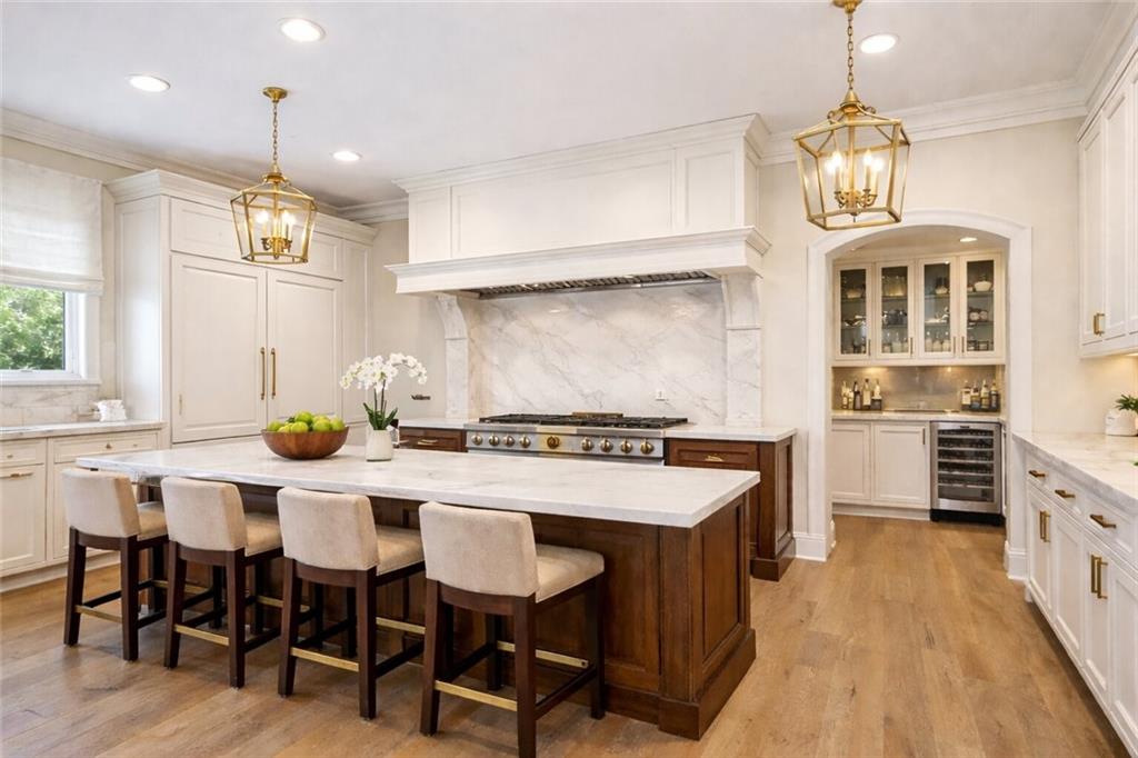 410 East Church Street Monroe, GA 30655 - Photo 11 of 50 a kitchen with stainless steel appliances a stove a sink dishwasher and white cabinets with wooden floor