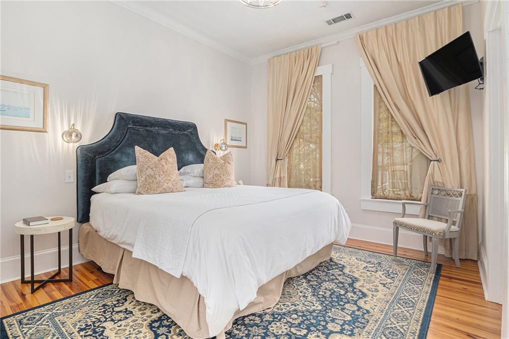 410 East Church Street Monroe, GA 30655 - Photo 31 of 50 a bedroom with a bed flat screen tv and a large mirror on a dresser