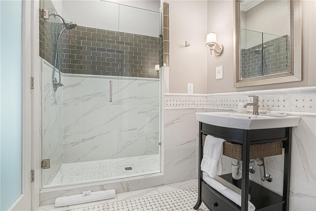 410 East Church Street Monroe, GA 30655 - Photo 32 of 50 a bathroom with a shower a sink and a mirror