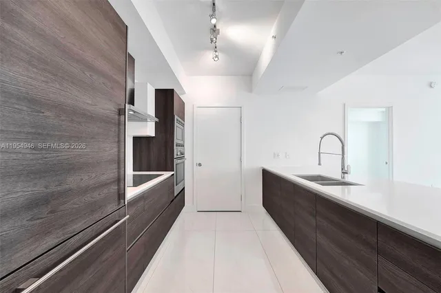 a kitchen with granite countertop a sink and refrigerator