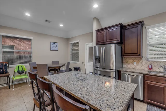 a kitchen with granite countertop kitchen island stainless steel appliances a table and chairs