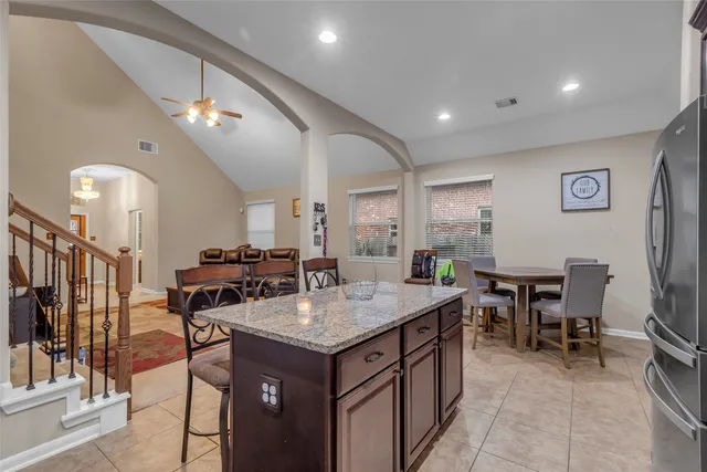a kitchen with a stove a refrigerator a dining table and chairs