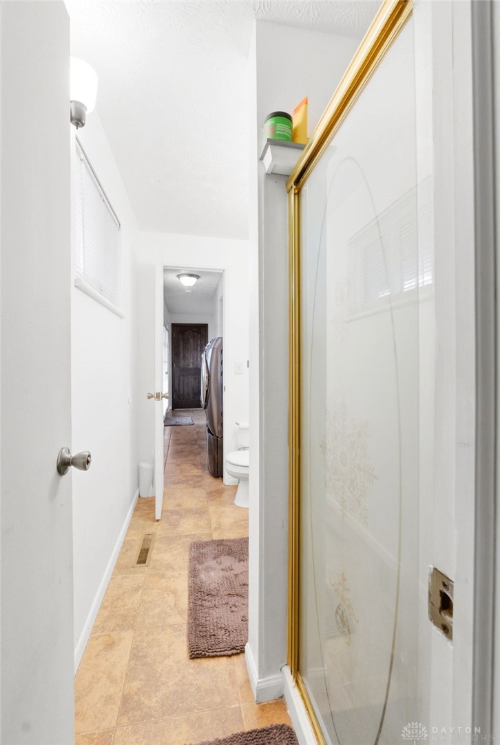 5171 Fishburg Road Dayton, OH 45424 - Photo 28 of 35 This functional hallway features a bathroom with a shower and offers additional utility space.
