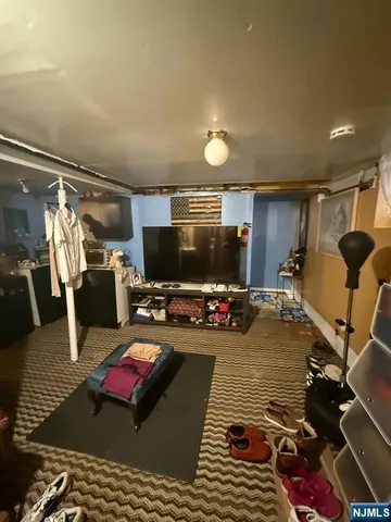 a gym room with furniture a flat screen tv and a window