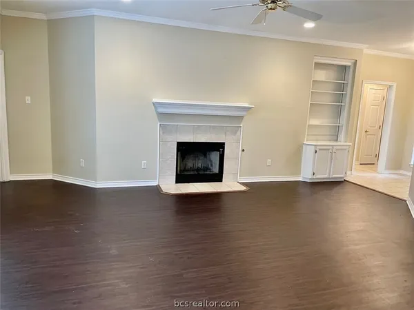 a view of a livingroom with wooden floor and a fireplace