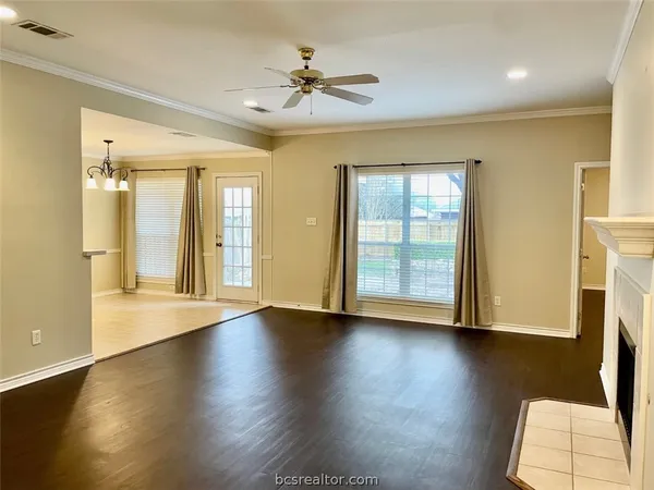 a view of an empty room with a window and wooden floor