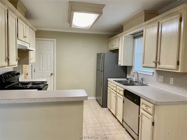 a kitchen with stainless steel appliances granite countertop a sink and a refrigerator