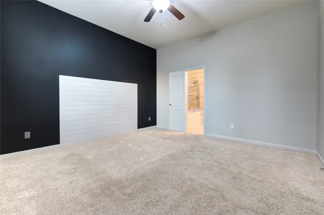 an empty room with a ceiling fan and window