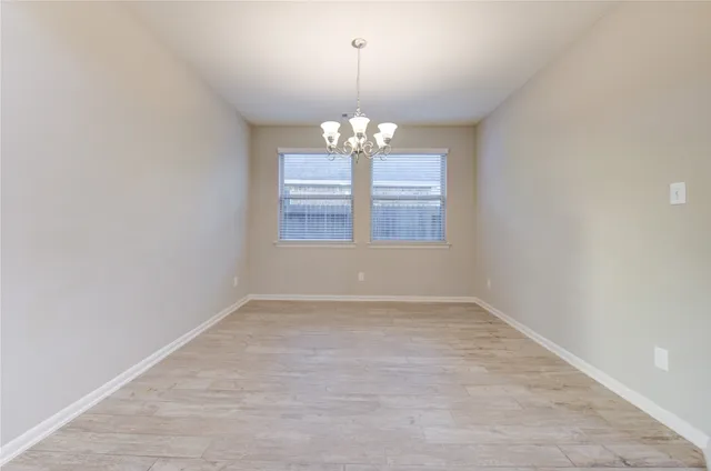an empty room with windows and chandelier