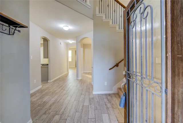 a view of a hallway with wooden floor and staircase