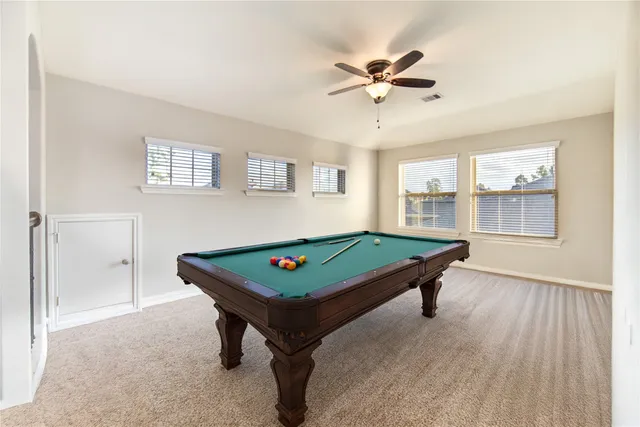 a room with pool table and windows