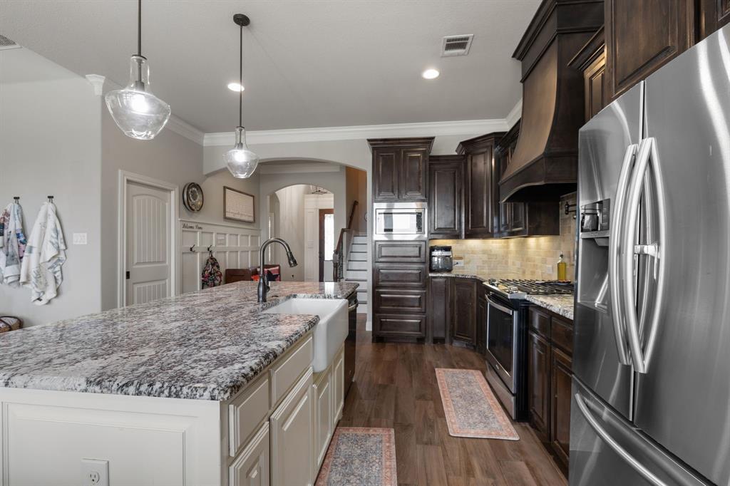 2103 Cash Point Court Granbury, TX 76049 - Photo 12 of 38 a kitchen with stainless steel appliances granite countertop a sink refrigerator and cabinets