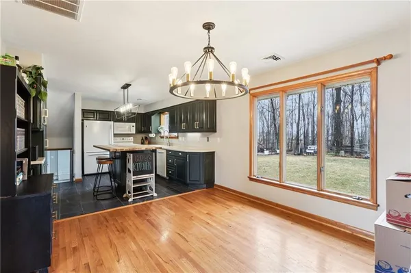 a dining room with wooden floor and a chandelier