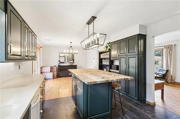 a kitchen with kitchen island granite countertop wooden cabinets a refrigerator and a sink