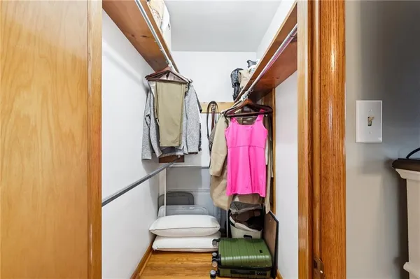 a view of walk in closet with clothes and shoes