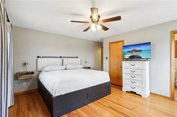 a bedroom with a bed and a ceiling fan