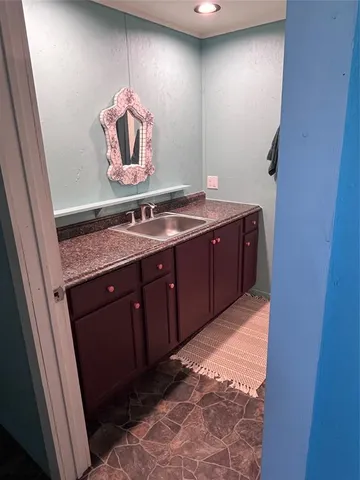 a bathroom with a granite countertop sink a mirror and vanity