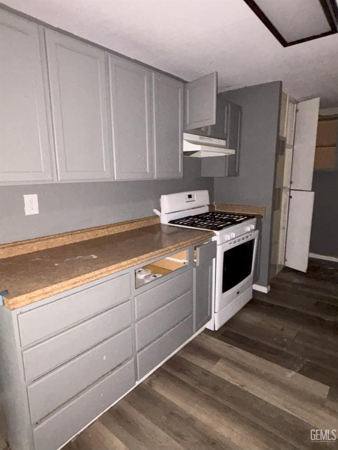Undisclosed Address Ridgecrest, CA 93555 - Photo 14 of 27 a kitchen with granite countertop a stove a sink and a white cabinets