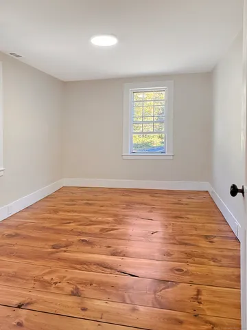 wooden floor in empty room with window