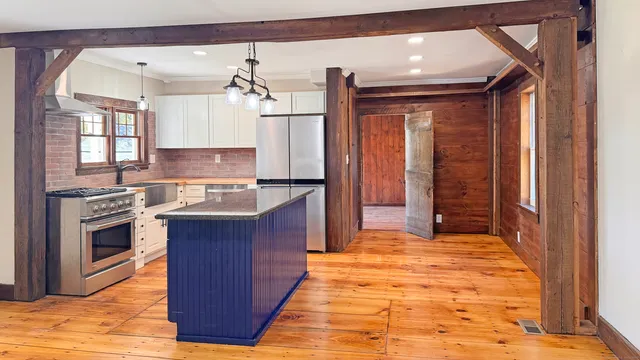 a large kitchen with kitchen island granite countertop a sink and a stove top oven