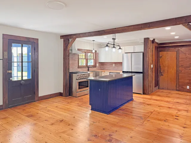 a kitchen with stainless steel appliances granite countertop a stove cabinets and wooden floor