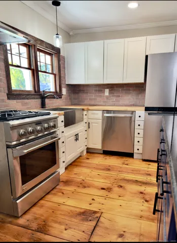 a kitchen with stainless steel appliances granite countertop a stove a sink and a microwave