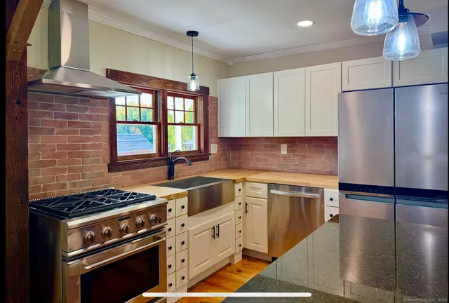a kitchen with stainless steel appliances granite countertop a stove a sink dishwasher and a refrigerator