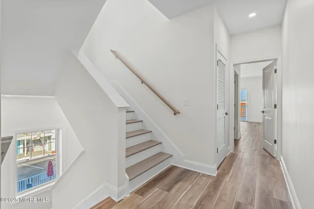 a view of a hallway with wooden floor and entryway