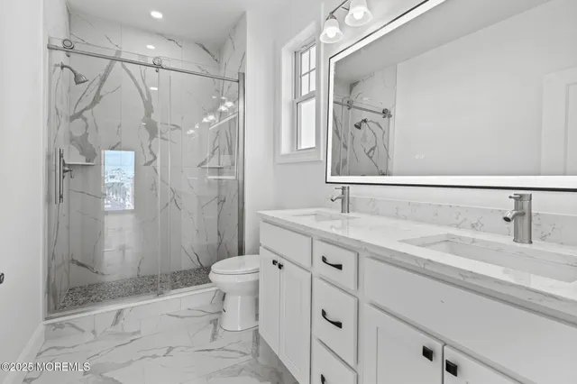 a bathroom with a granite countertop sink toilet and shower