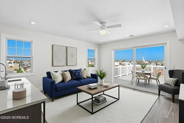 a living room with furniture kitchen view and a window