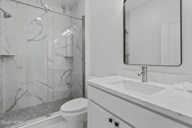 a bathroom with a sink a toilet and shower