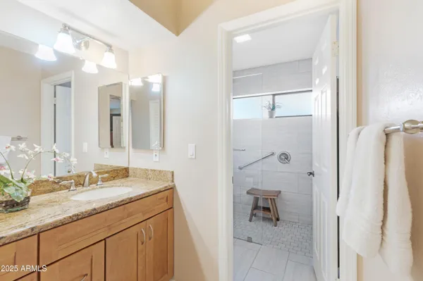 a bathroom with a granite countertop sink vanity and mirror