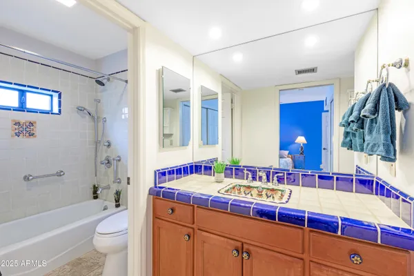 a bathroom with a bathtub a sink and a large mirror
