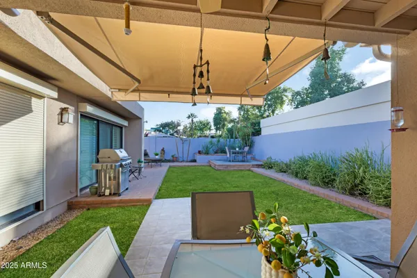 a view of a porch with a table and chairs under an umbrella