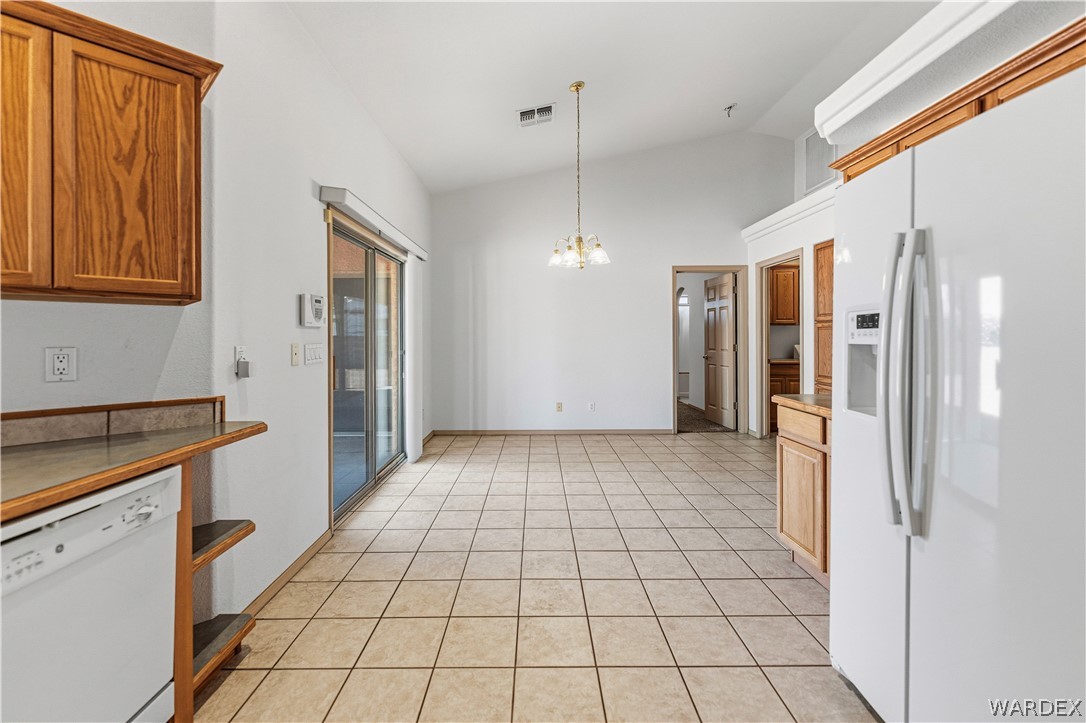 3973 Prairie View Drive Kingman, AZ 86409 - Photo 16 of 34 The kitchen and dining area features tile flooring, vaulted ceilings, and a sliding glass door providing access to the exterior