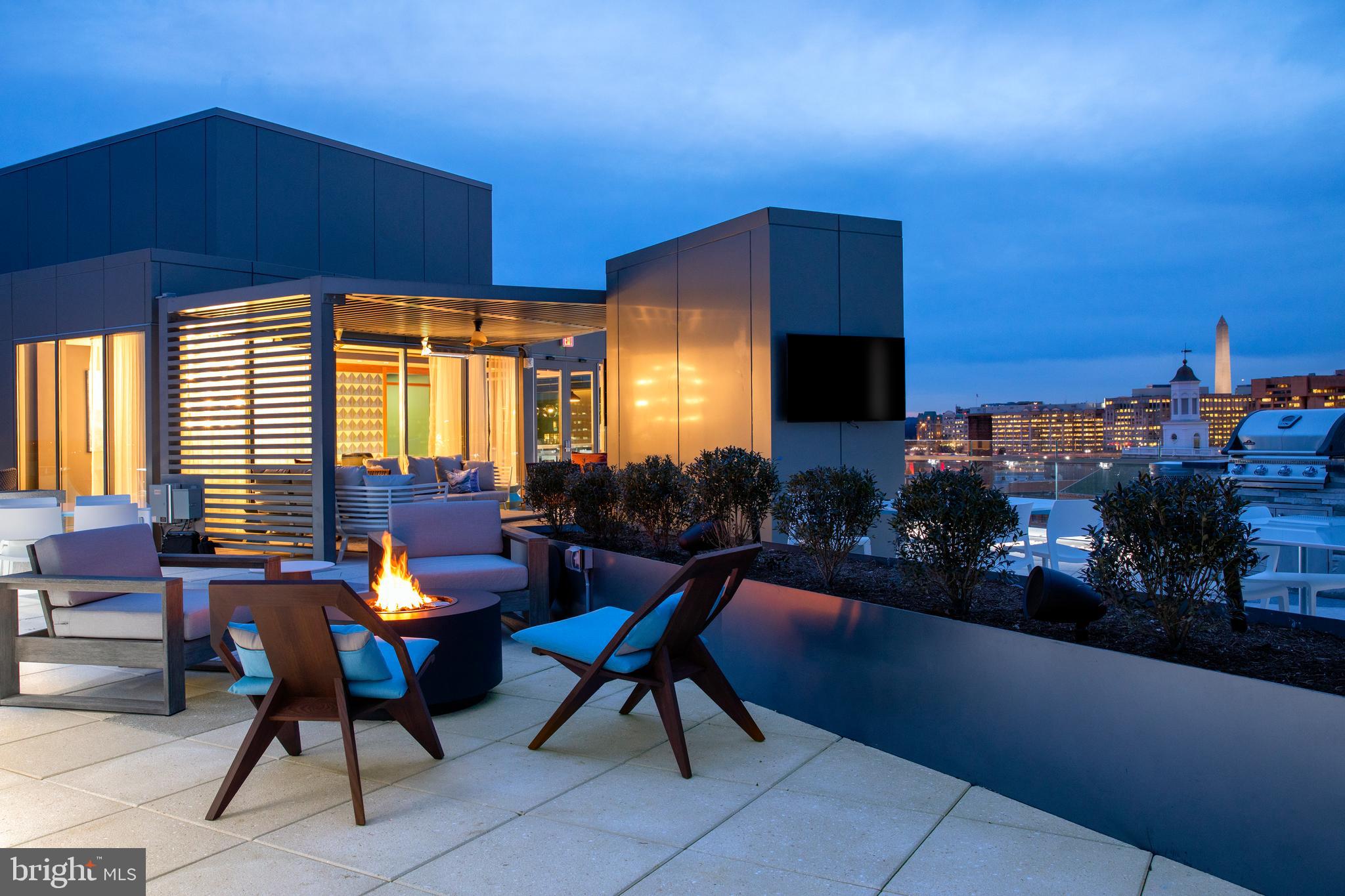 900 7th Street Southwest, Unit PH04 Washington, DC 20024 - Photo 15 of 25 a living room with patio furniture and a fireplace